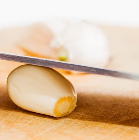 Amasse o alho com a lateral da faca em vez de descascar